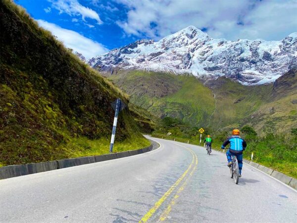 Cyclists descending the Inca Jungle Trail through lush Andean terrain