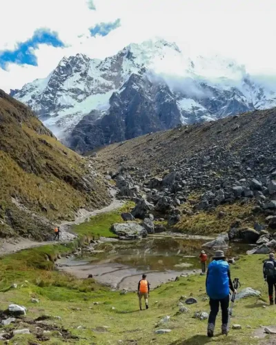 Beginner hiker using trekking poles on the Salkantay Trek, navigating a steep incline.