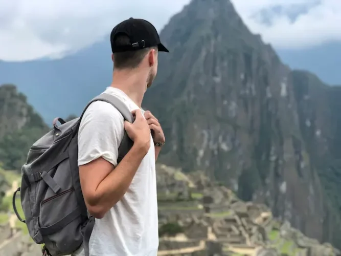 Traveler with a backpack at the summit of Machu Picchu.